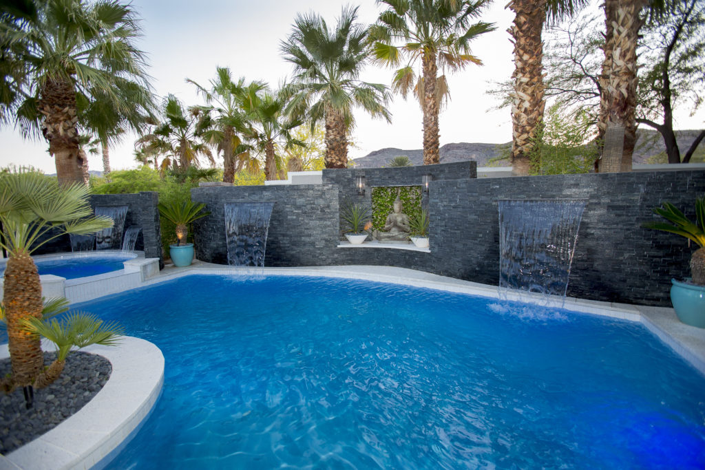 Swimming pool with fountains and some tropical trees