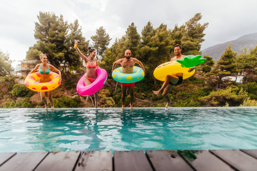 Adults jumping in the pool