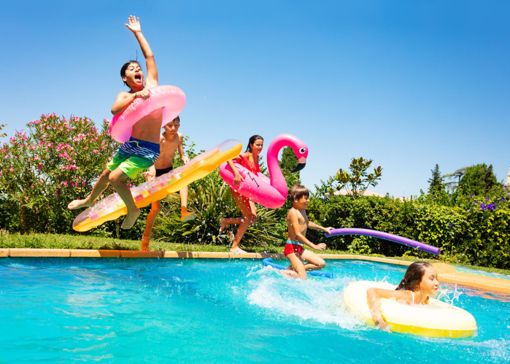 The kids are enjoying jumping in the pool in the Summer time